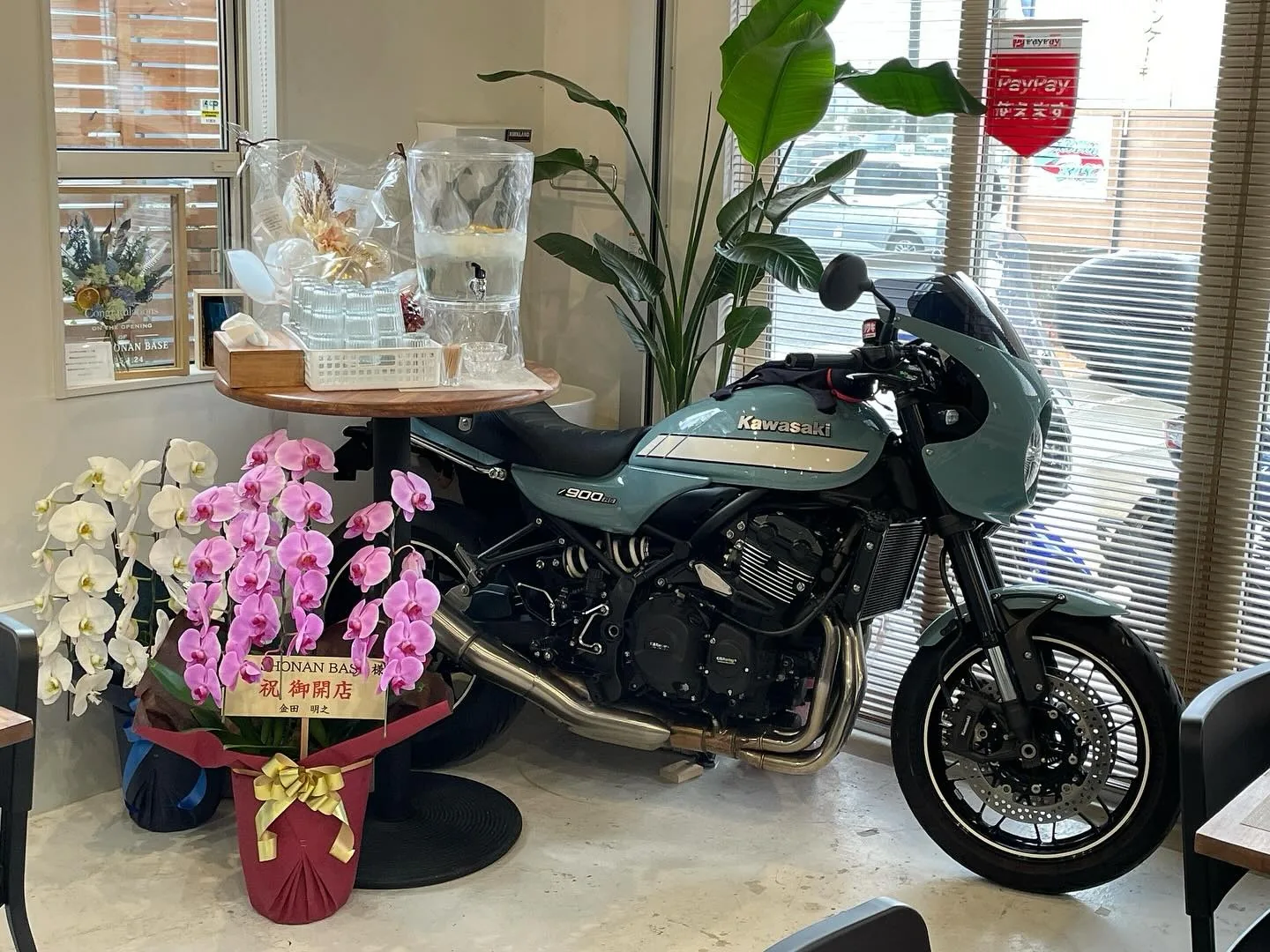 窓辺のバイクと木のテーブルが見える店内
